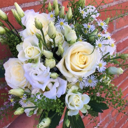 Bouquet de fleurs blanches accroché à un mur